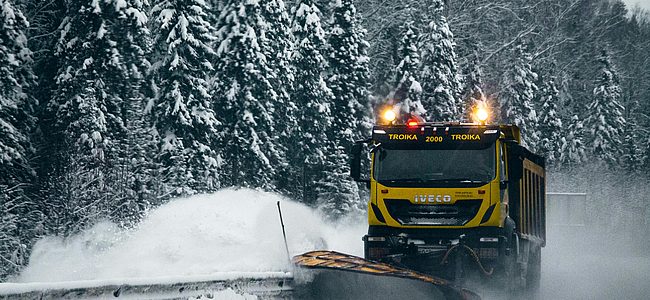 Winterdienst-Fahrzeug räumt verschneite Straße mit Schneepflug im Einsatz