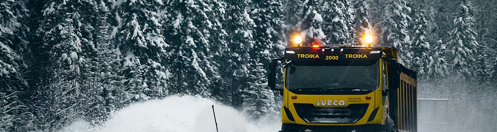 Winterdienst-Fahrzeug räumt verschneite Straße mit Schneepflug im Einsatz