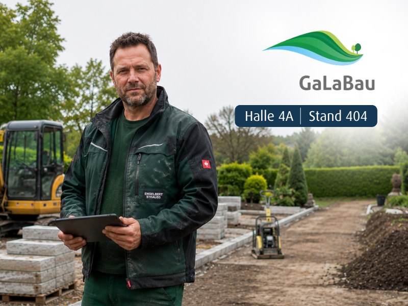 Mann in Arbeitsklamotten auf Baustelle hält Tablet in der Hand 